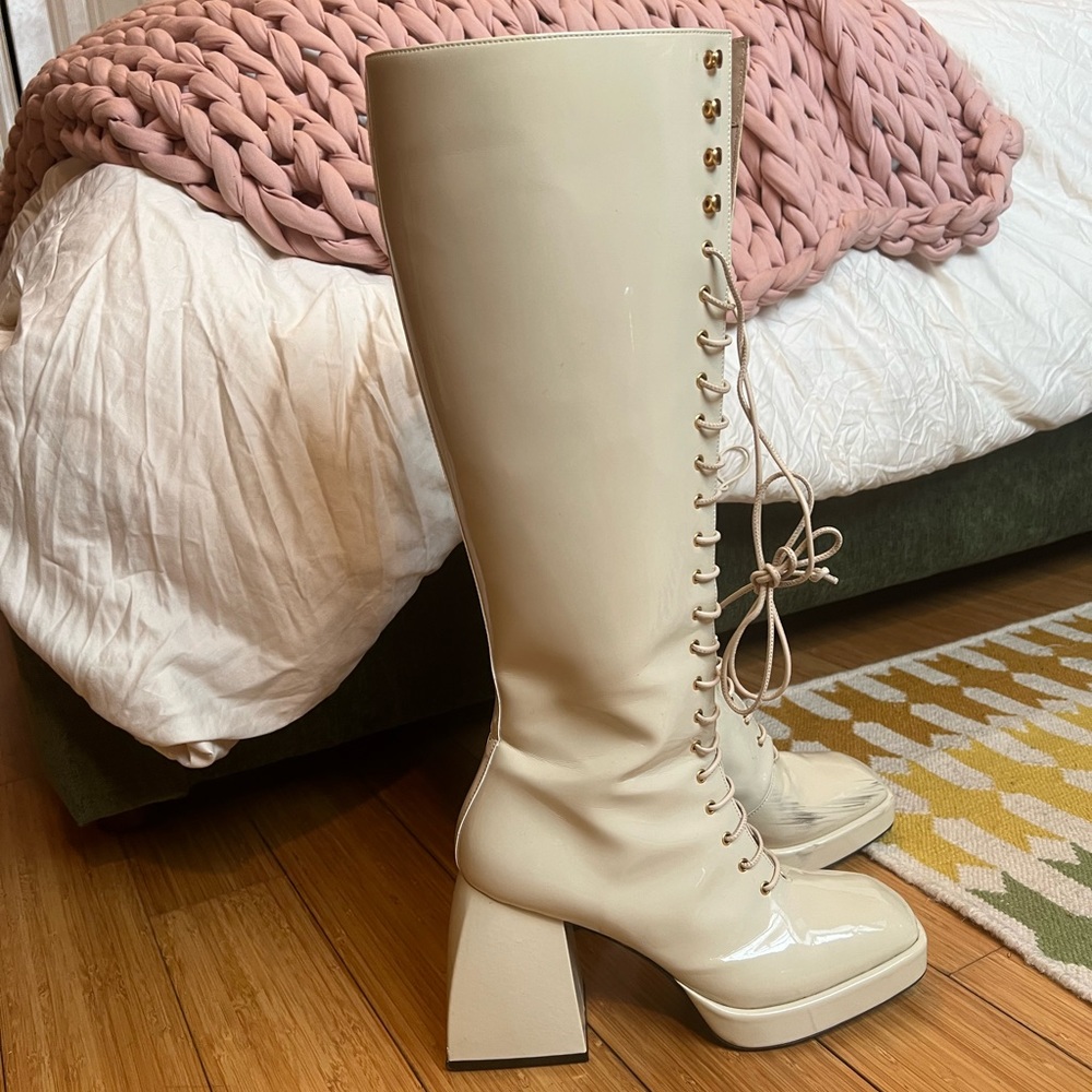Nodaketo Bulla Ward Patent Leather Knee High Lace-Up Boots in Ecru